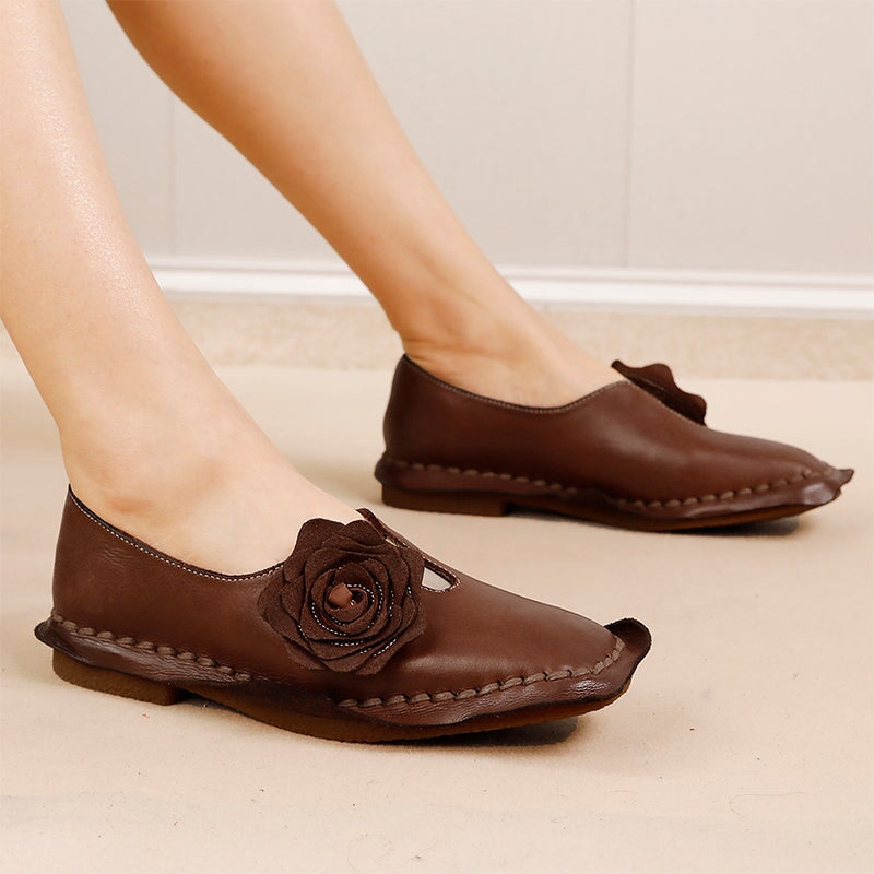 Elegante platte loafers van gewassen rundleer met bloemversiering in camel/koffiekleur.