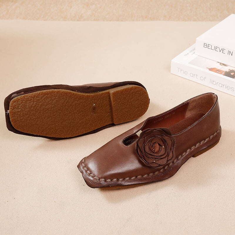 Elegante platte loafers van gewassen rundleer met bloemversiering in camel/koffiekleur.