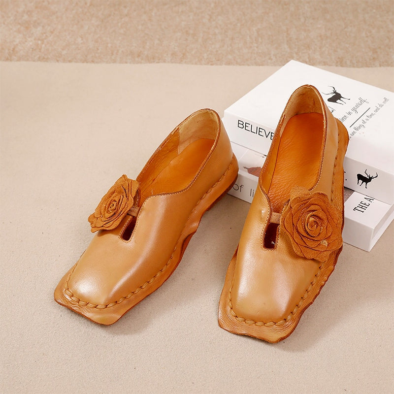 Elegante platte loafers van gewassen rundleer met bloemversiering in camel/koffiekleur.