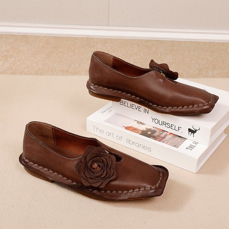 Elegante platte loafers van gewassen rundleer met bloemversiering in camel/koffiekleur.
