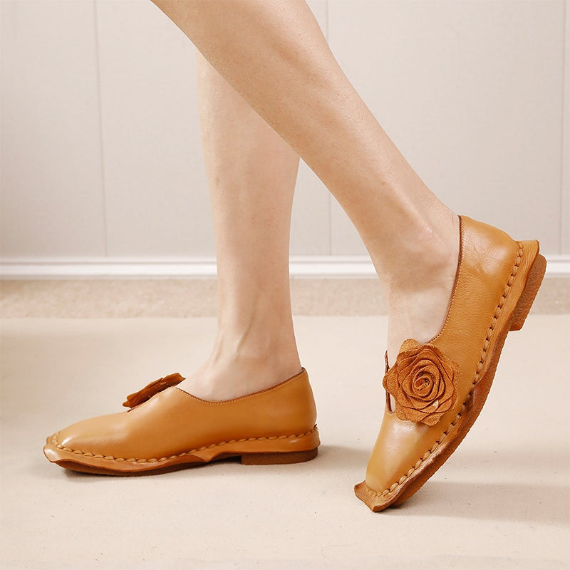 Elegante platte loafers van gewassen rundleer met bloemversiering in camel/koffiekleur.