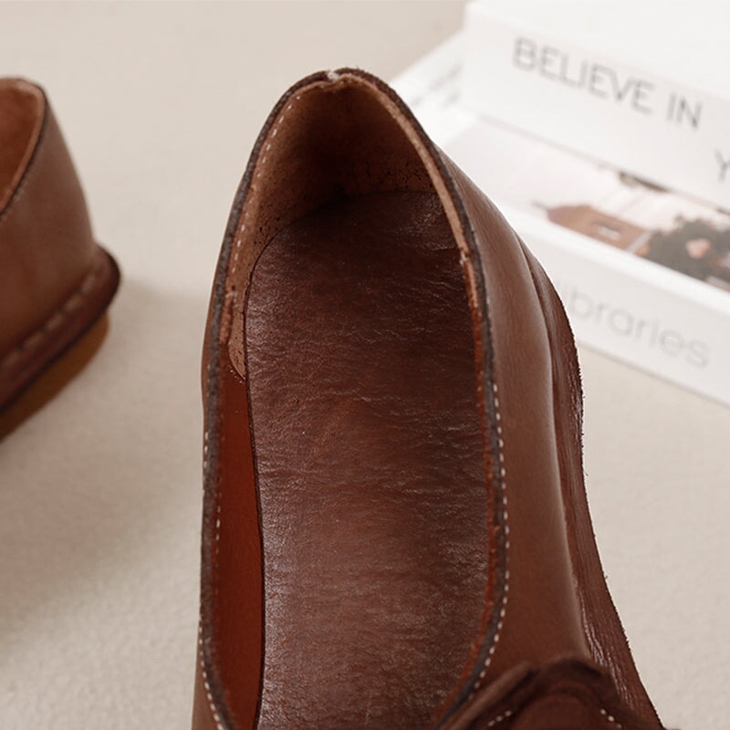 Elegante platte loafers van gewassen rundleer met bloemversiering in camel/koffiekleur.