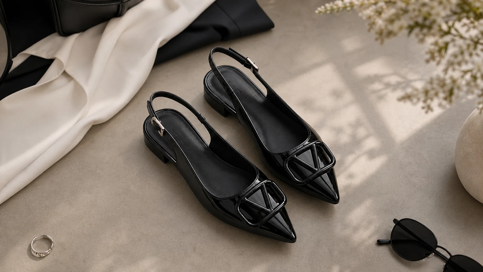 Black patent-look buckle slingback flats styled in a horizontal fashion scene
